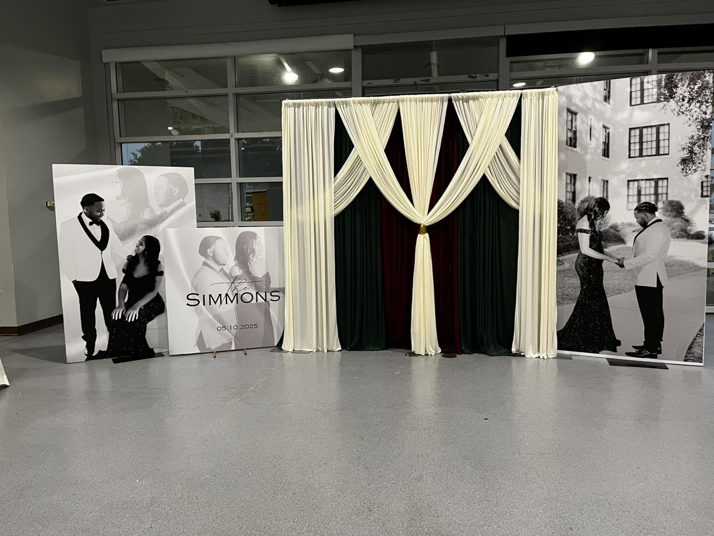 Elegant wedding photo boards flanking a draped backdrop