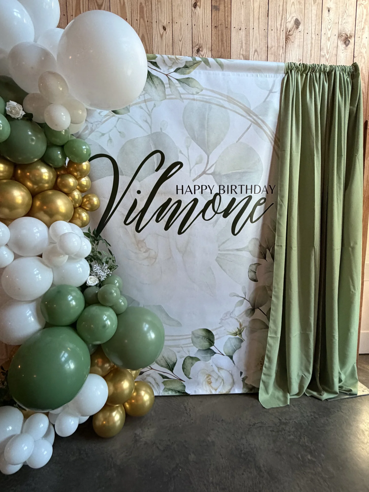 Sage, gold and ivory balloon garland surrounding a custom name backdrop