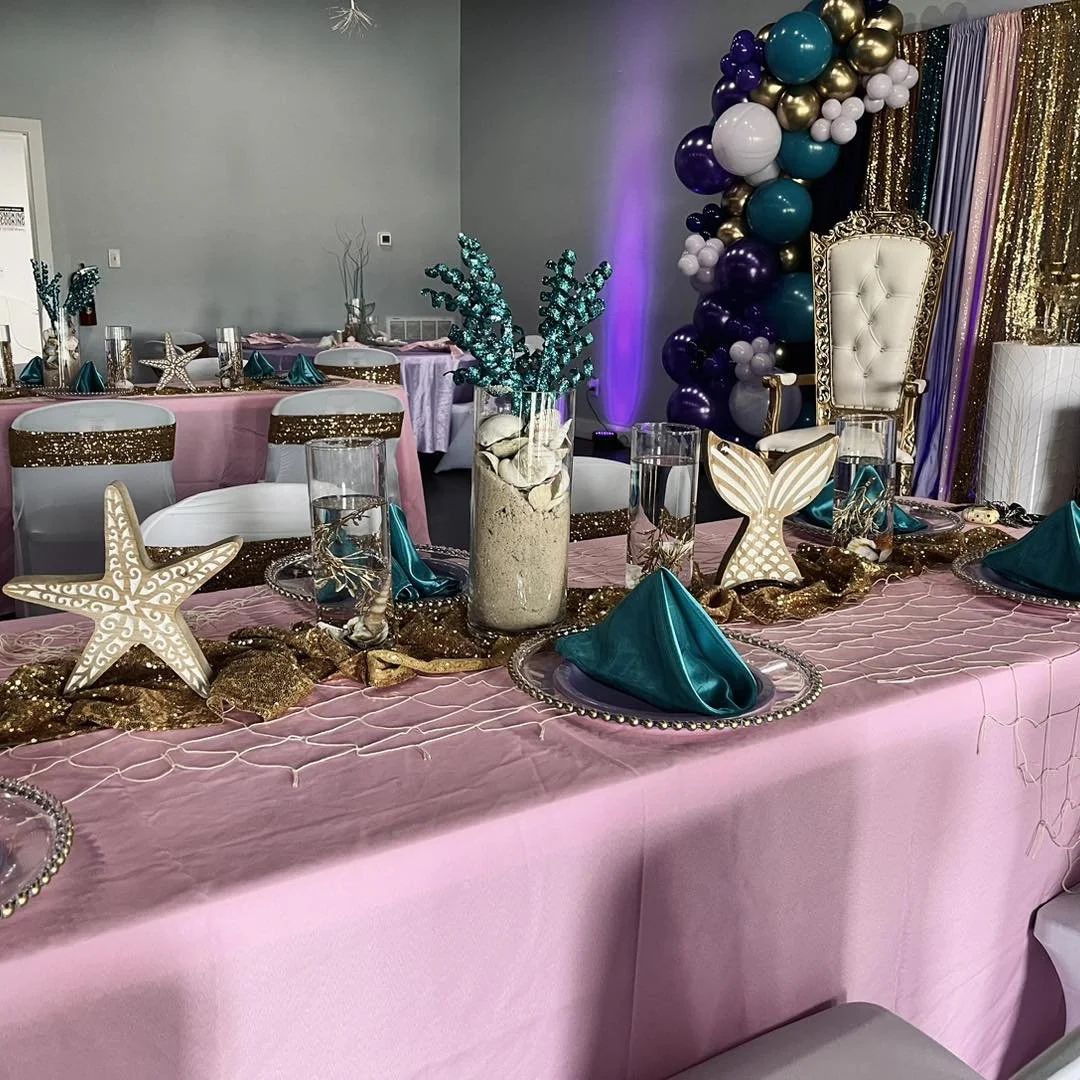A designer arranging an elegant tablescape with florals and candlelight