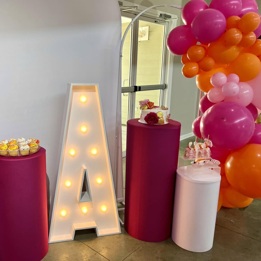 Marquee letter A with a pink and orange dessert display