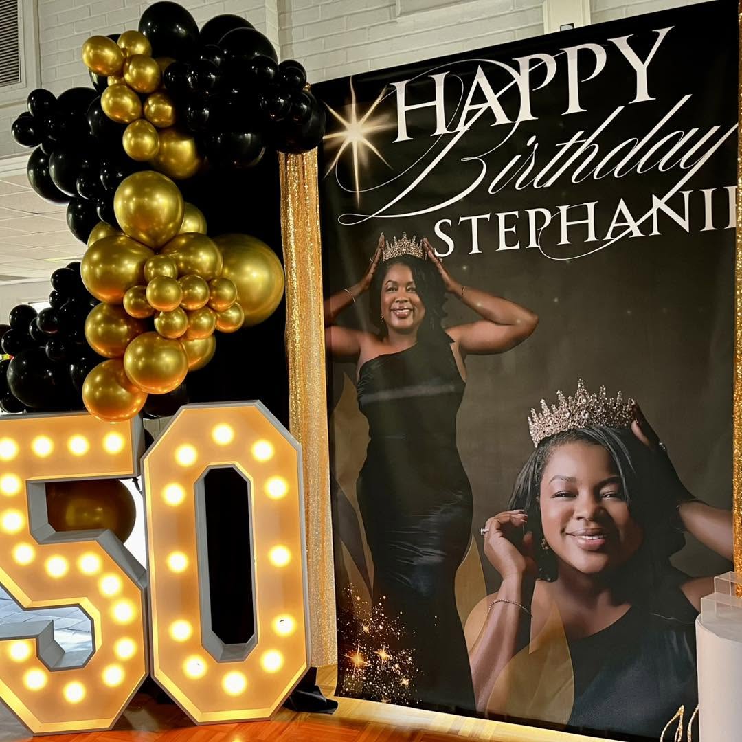 Custom printed celebration backdrop behind a styled table