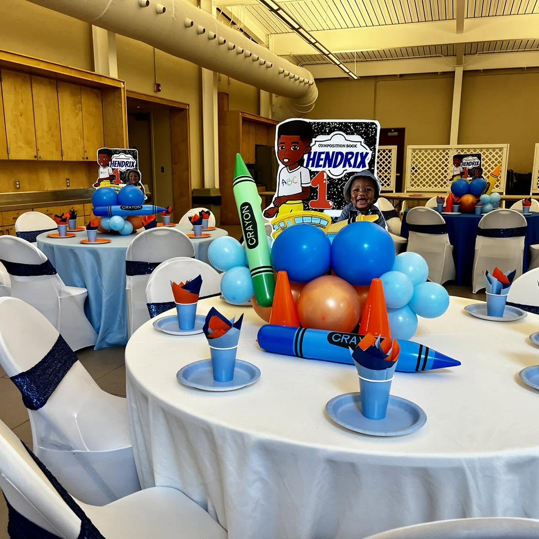 School-themed crayon centerpiece props and balloon accents on a styled kids party table