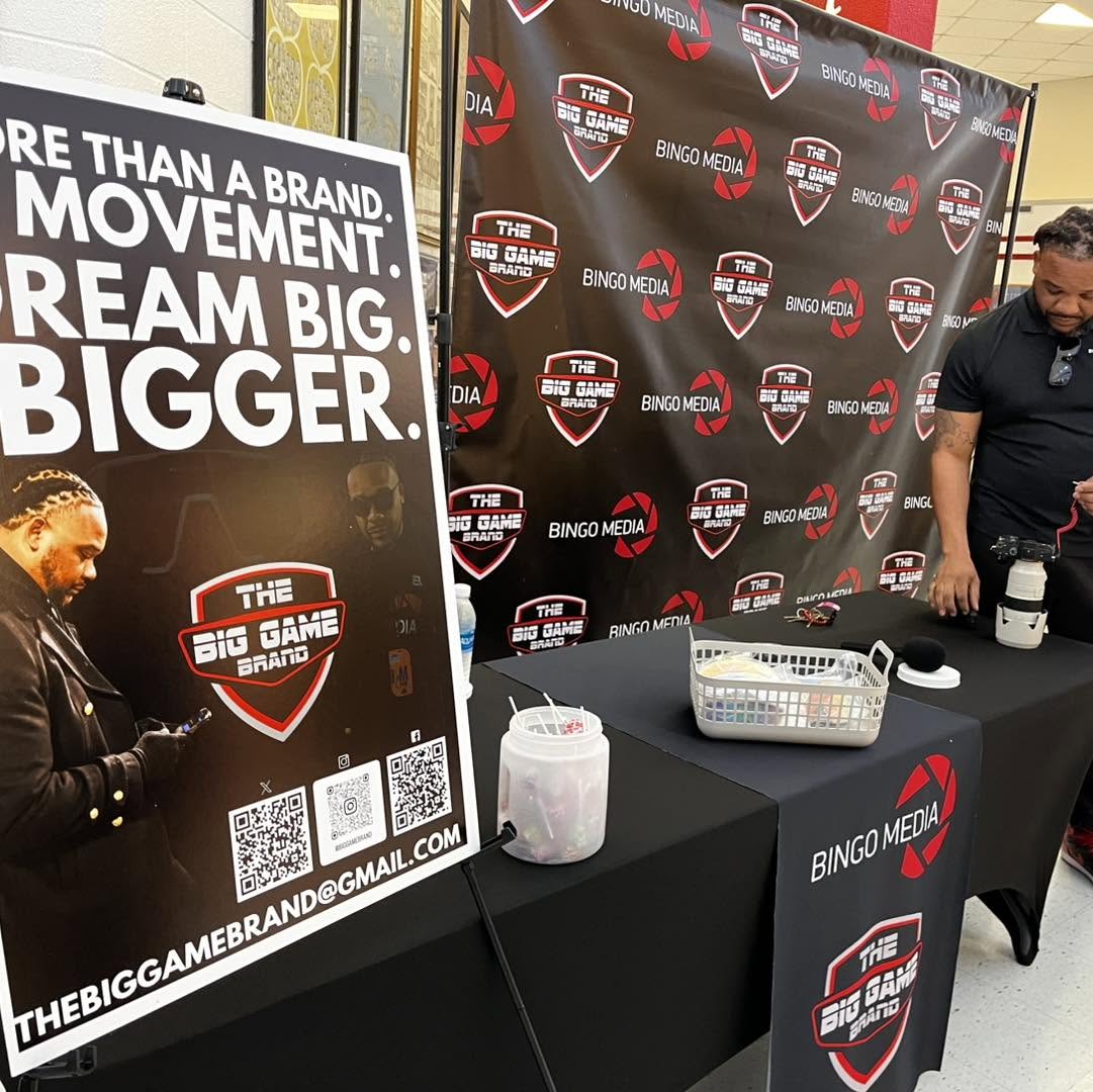 Big Game Brand and Bingo Media branded step-and-repeat with linen-draped display table