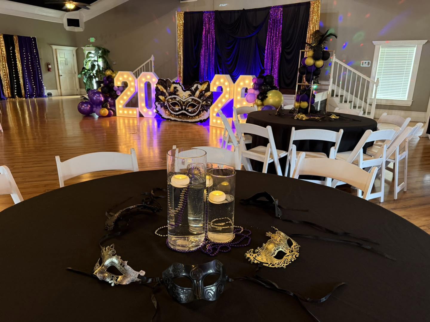 Masquerade ballroom with styled tables, candlelight and illuminated marquee numbers